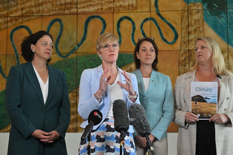 four women standing at microphone