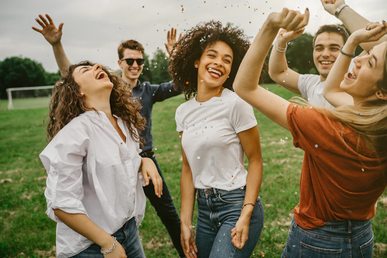 Group of friends dancing in a field