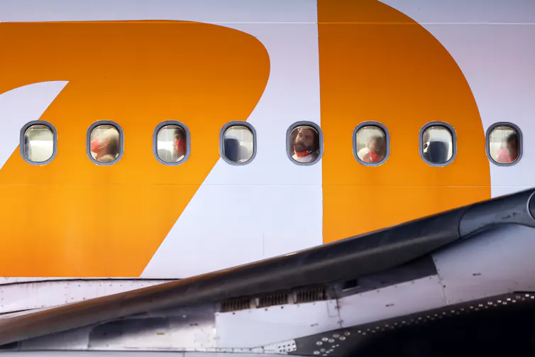 Men looking out of the cabin of a large airplane.