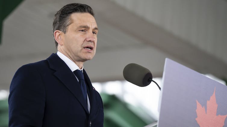 Un hombre con un de mediana edad que usa un traje oscuro que habla en el podio