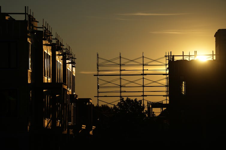 La silueta de una construcción se puede ver andamios al sol repentinamente