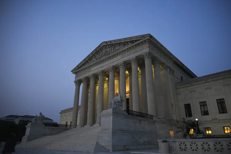 The US Supreme Court building is seen at dusk.