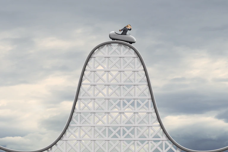 An image shows a figure on the top of a roller coaster.