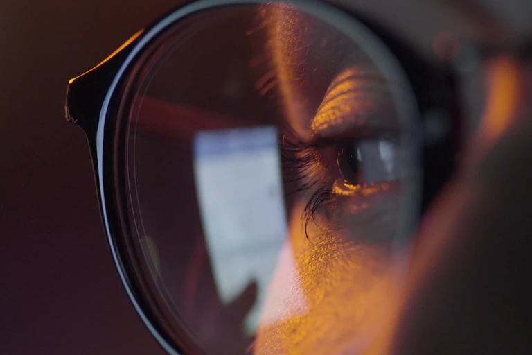 Close up of female eye with online screen reflected in glasses