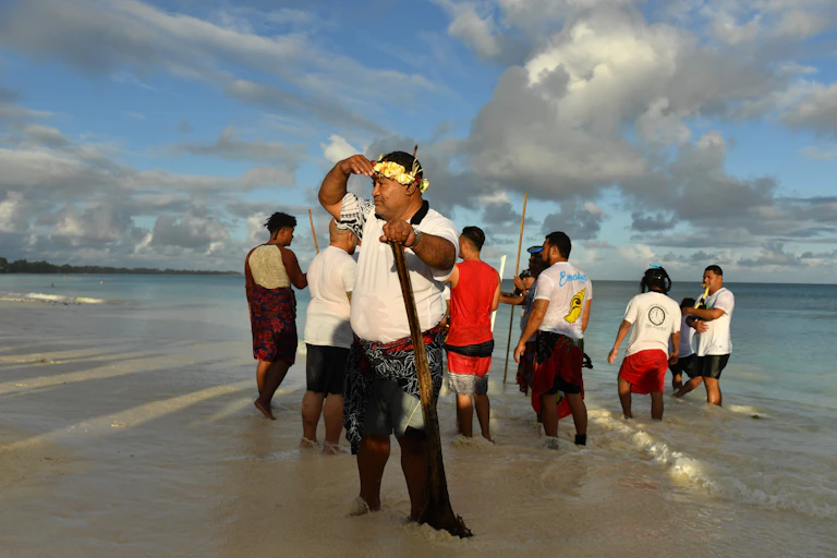 Locals during a traditional fishing practice to round up fish to be cooked on an umu (traditional earth oven) by the lagoon in Funafuti, Tuvalu