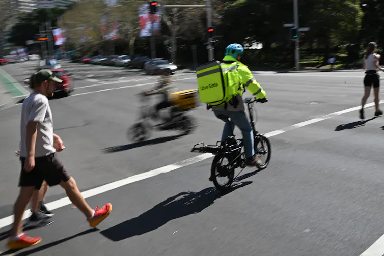A delivery driver rides a bicycle