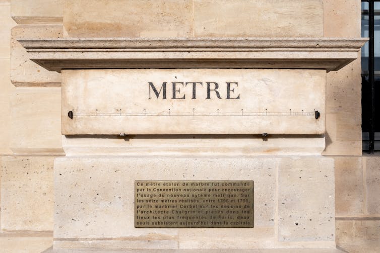 a stone pillar on building engraved with the word metre