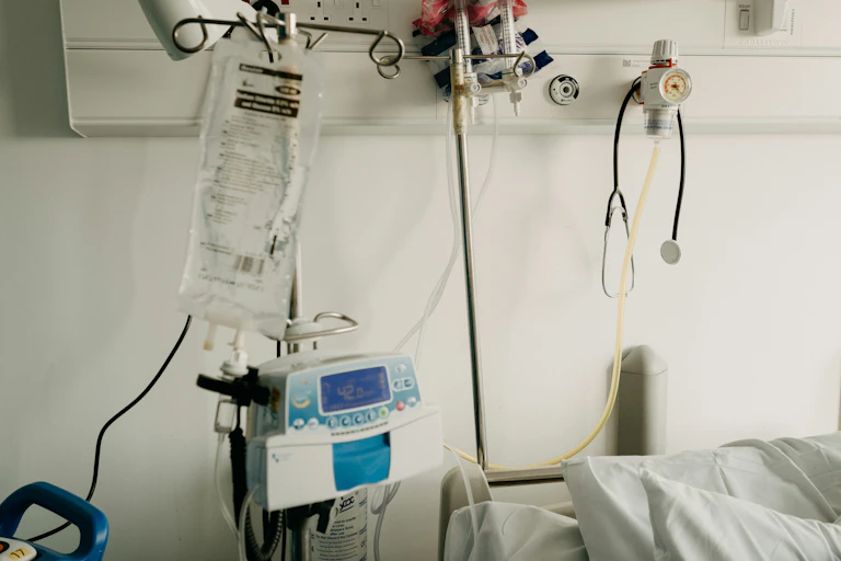 A hospital room with a bed and medical equipment.