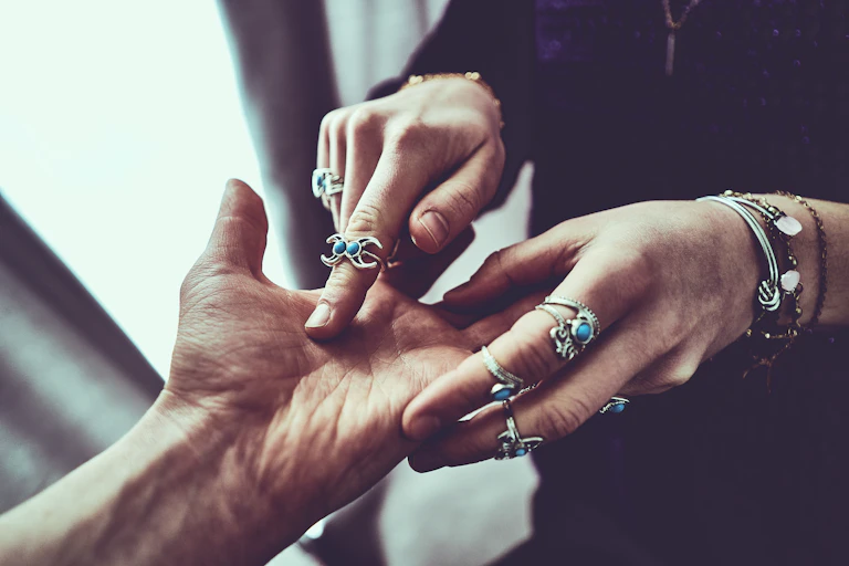 Woman's hands trace the lines on a man's hands