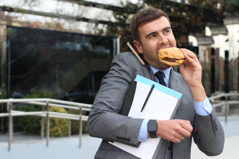 Hombre de negocios comiendo una hamburguesa.