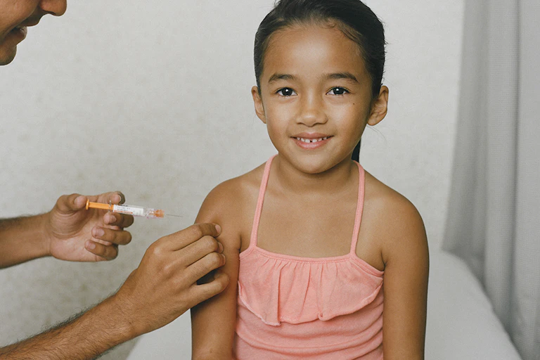 Smiling young girl being vaccinated