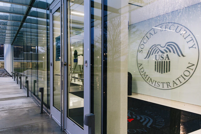 Photo of an office that has the Social Security Administration seal visible through a large window.
