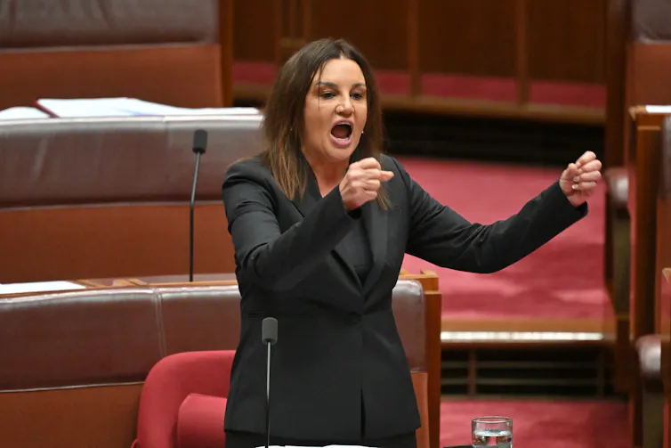 Jacqui Lambie stands up in the senate and gestures