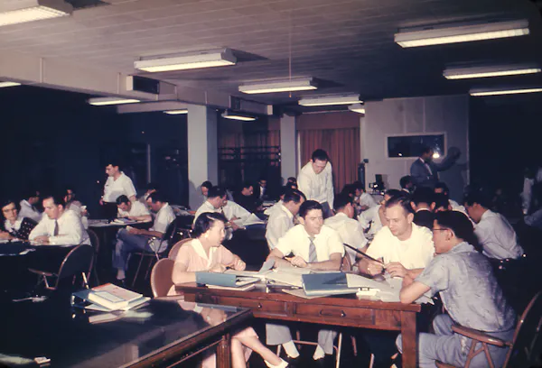 People sit around multiple tables during a training course