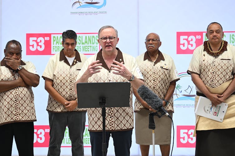 five men in matching shirts standing on stage