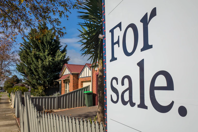 A for sale sign in front of a house