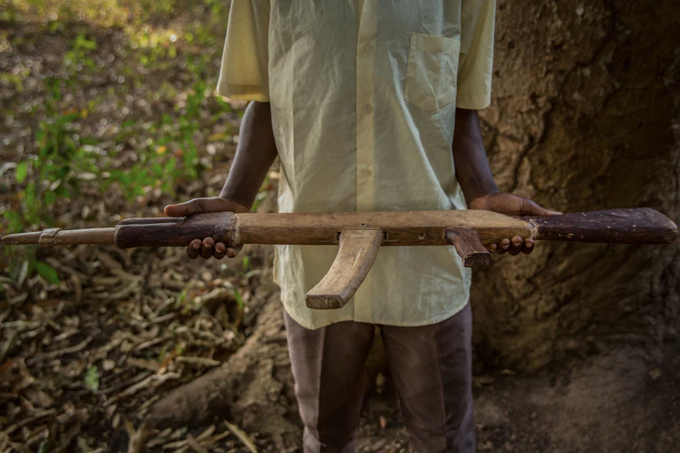 Child holds a wooden gun