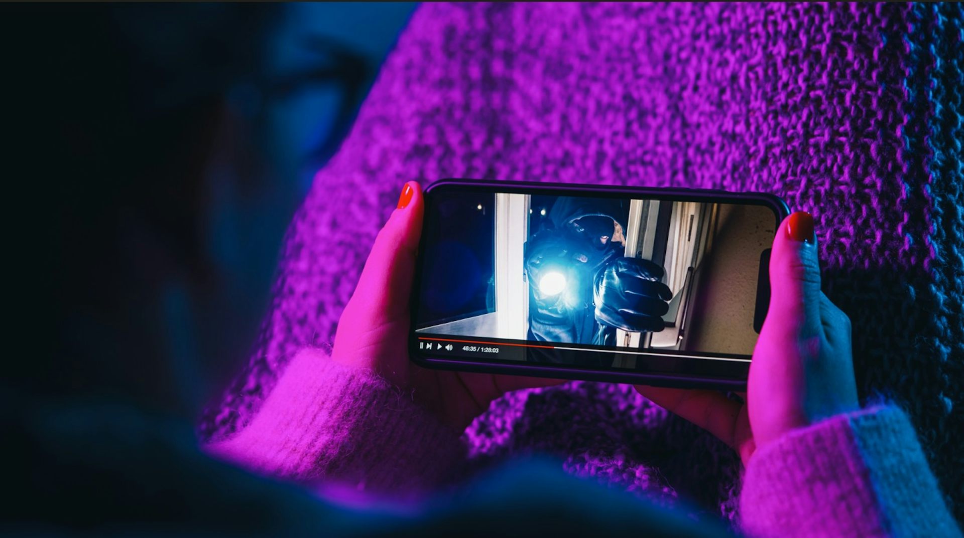 Une femme regarde un film sur son téléphone