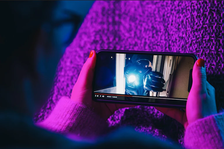 Une femme regarde un film sur son téléphone