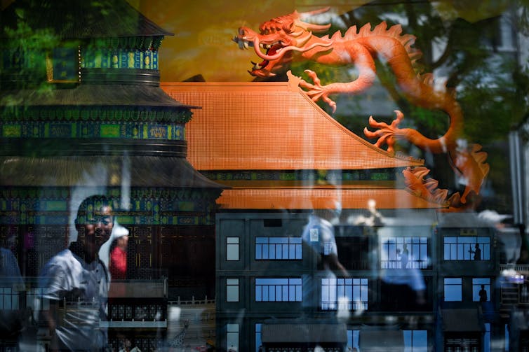 A model dragon is seen through a shop window.