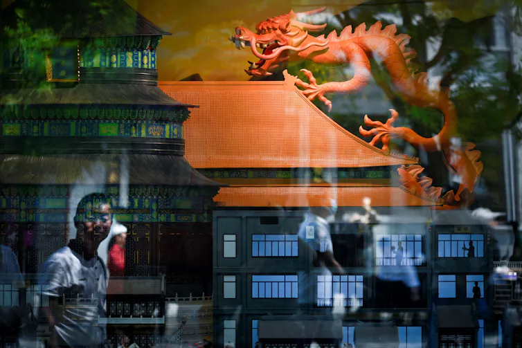 A model dragon is seen through a shop window.
