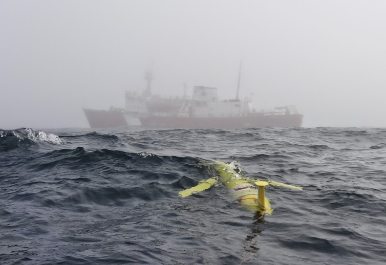a yellow vessel floating just below the ocean surface