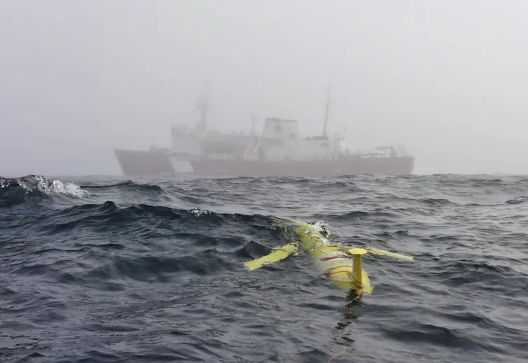 a yellow vessel floating just below the ocean surface