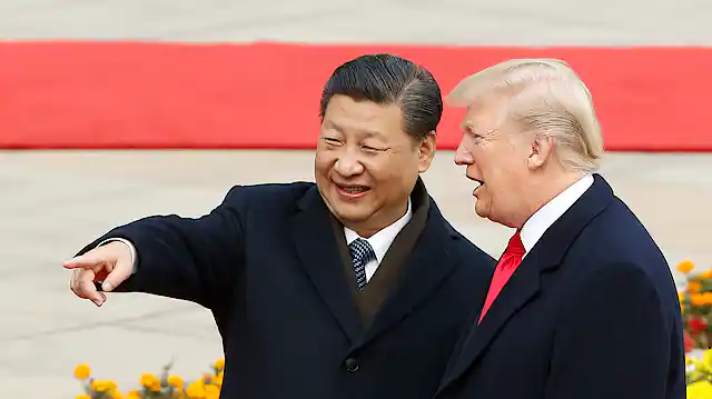 Two men in suits stand and point.
