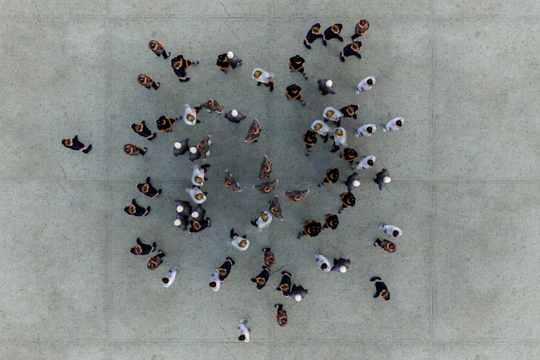 aerial view of a clump of people standing on a concrete surface