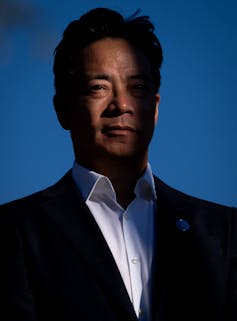 Hombre del este de Asia en años intermedios en una chaqueta para trajes oscuros y camisa blanca