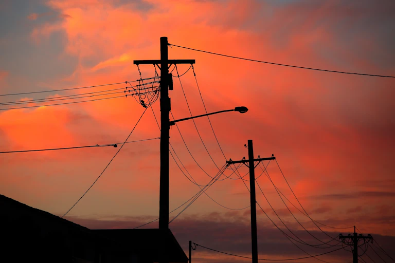 Power lines against a red sky