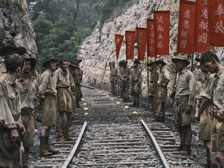 Production image: soliders line up along a railway.