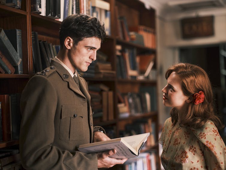 Production image: a young man and a woman in a library.