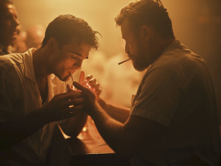 Production image: two men light cigarettes.