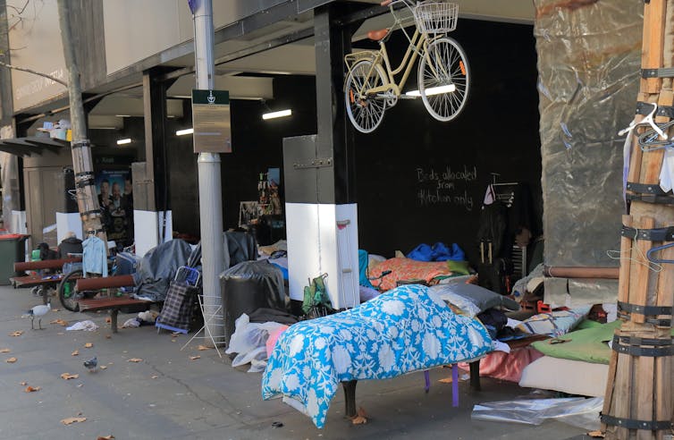 Ratal sidewalks with a person hanging down the blue and white blanket and a hook under a bicycle under a bicycle