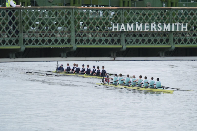 Two rowing eights go under a bridge