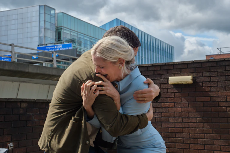 Two crying people embracing