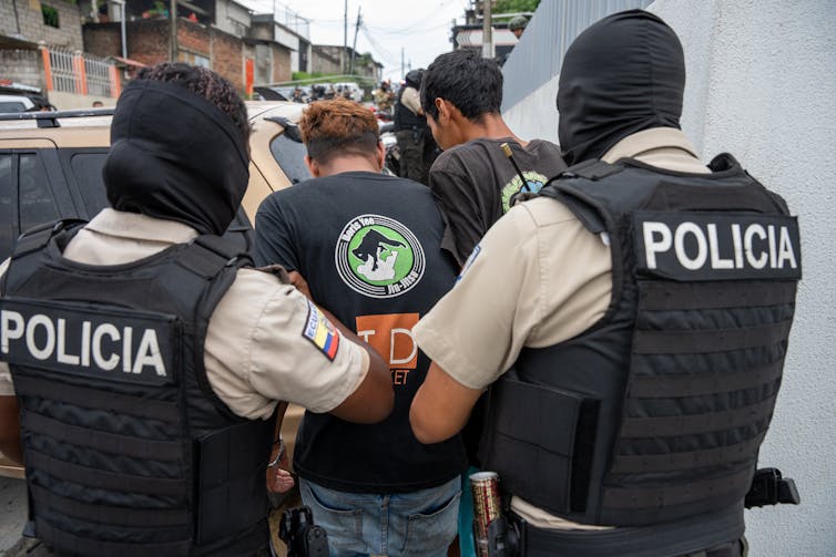 Ecuadorian security forces detaining two men.