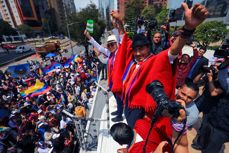 Leonidas Iza dressed in a red robe addressing a crowd of supporters.