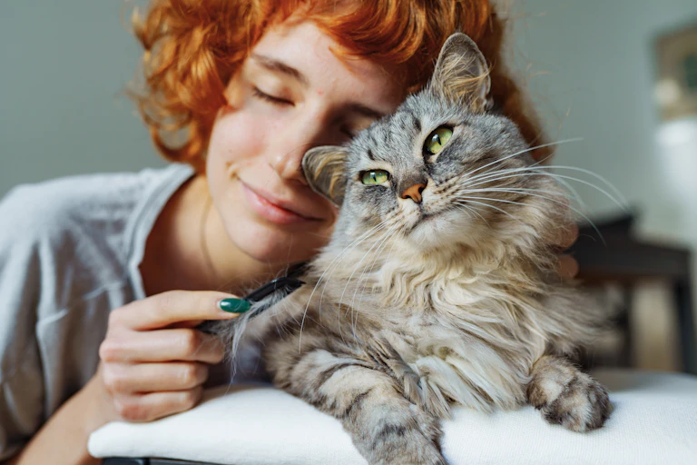 Girl with red hair cuddling cat