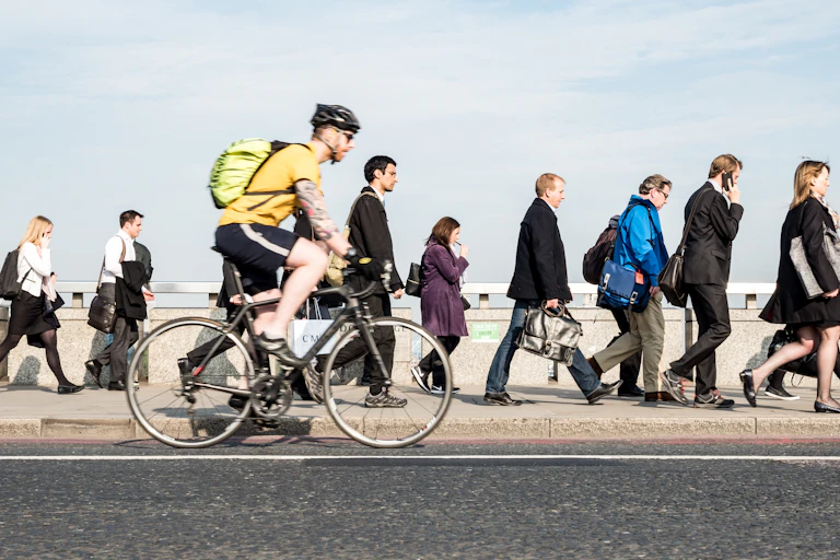 commuters on foot or bike crossing a bridge