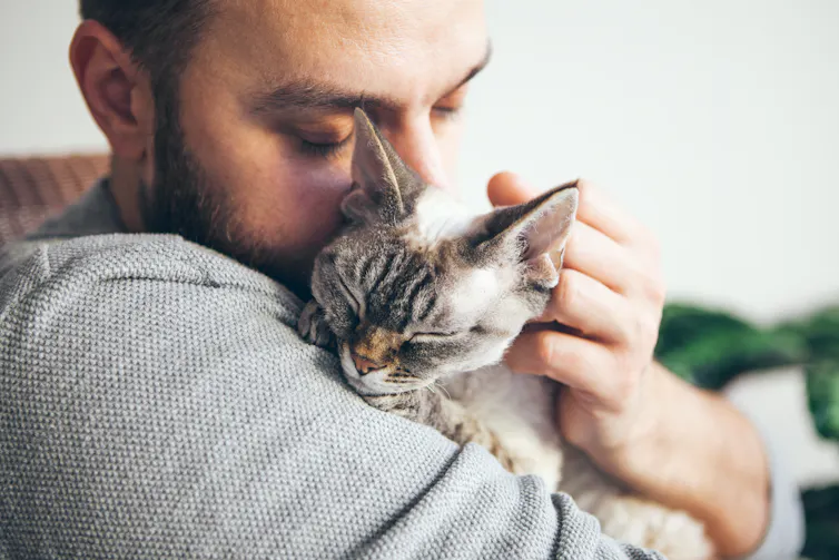 Man snuggling with cat.