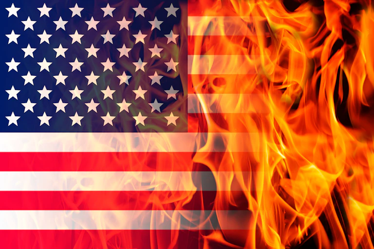 An American flag, half of which is in flames.