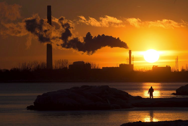 Las opciones federales canadienses no parecen ser el cambio climático, pero en realidad es 1 El hombre ha fotografiado el sol mientras una chimenea de humo de humo en el cielo naranja