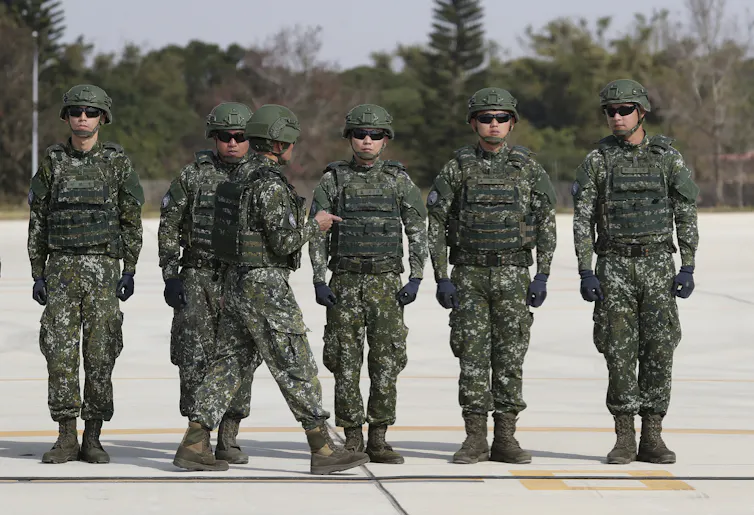 Uniformed soldiers stand together.