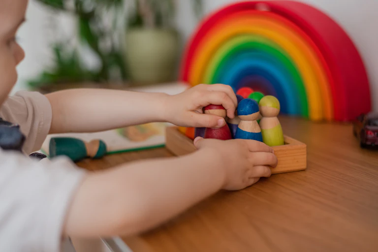A young child plays with wooden figures.