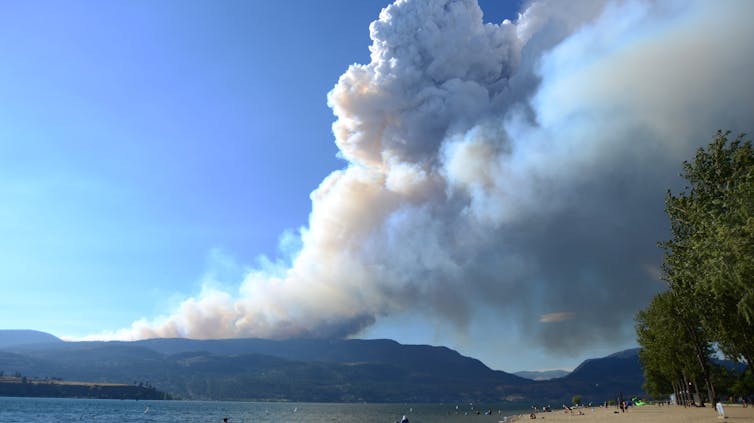 Un enorme plato de humo que se eleva sobre la colina en la orilla opuesta del lago