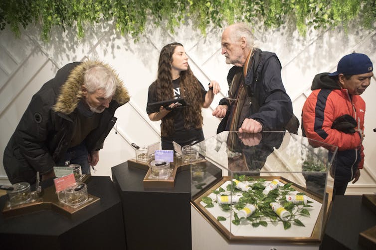 People in a store with tables displaying various cannabis products