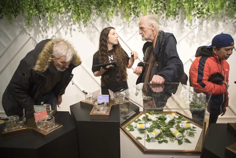 People in a store with tables displaying various cannabis products