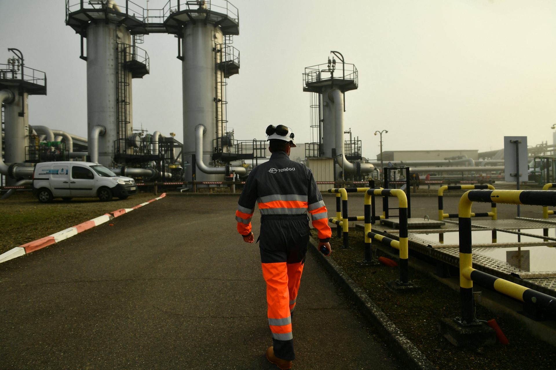 homme de dos en tenue de sécurité marche dans un environnement industriel